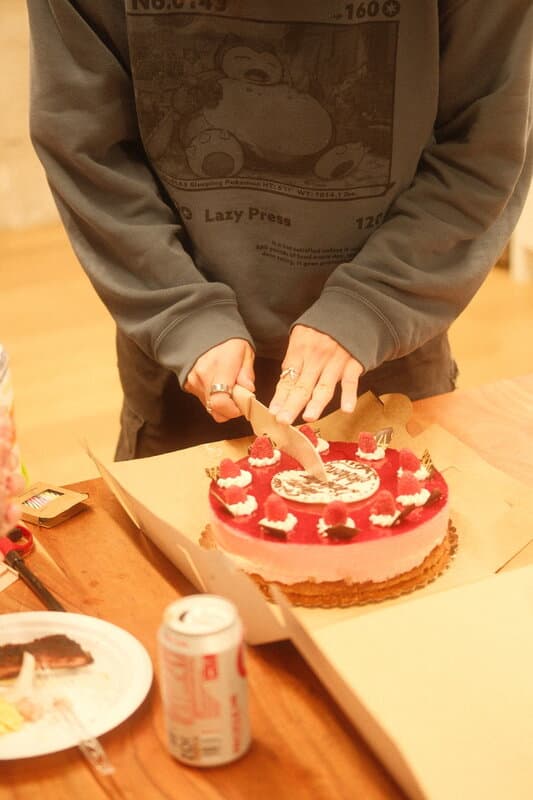 Cutting a raspberry cake in the office